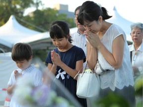Family members offer prayers for the atomic bomb victims at the Peace Memorial Park in Hiroshima on Monday. A US B-29 plane dropped a bomb over the city at 8:15am on Aug. 6, 1945, marking the first use of an atomic weapon, which ultimately claimed the lives of 140,000 people.