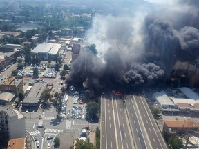 This handout picture taken from an helicopter and released by the Vigili del Fuoco, the Italian firement, on August 6, 2018, shows black smoke rising in the sky after a tanker exploded on the motorway close to the airport, in Bologna.