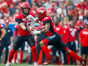 Stampeders quarterback Bo Levi Mitchell hands off to running back Don Jackson during Saturday's game against the Blue Bombers in Calgary. Al Charest/Postmedia
