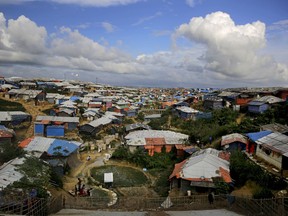 Rohingya refugees bathe at a hand water pump at Kutupalong refugee camp, where they have been living amid uncertainty over their future after they fled Myanmar to escape violence a year ago, in Bangladesh, Sunday, Aug. 26, 2018.