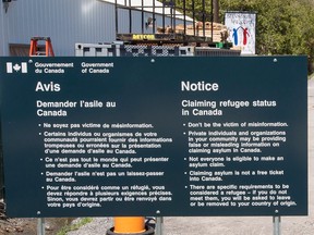 A sign warning asylum seekers is seen at the Canada/U.S. border at Roxham Road in Champlain, NY., on May 9, 2018.