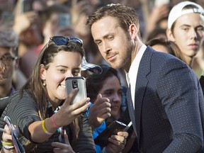 Ryan Gosling poses for a photo with a fan on the red carpet for the film "La La Land" during the 2016 Toronto International Film Festival in Toronto on Monday, Sept. 12, 2016.