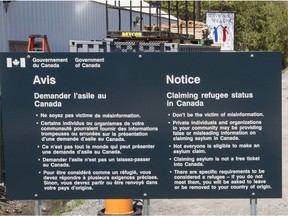 A sign warning asylum seekers is seen at the Canada/US border at Roxham Road.