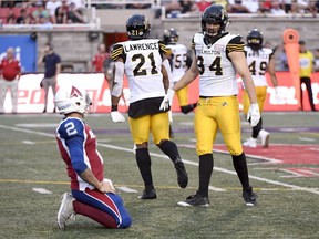 Hamilton defensive end Justin Capicciotti (94) and linebacker Simoni Lawrence (21) celebrate a pass interception against Montreal QB Johnny Manziel in the first quarter of Friday's CFL game.
