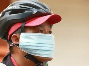 Cyclist Quong Tran pauses as he wheels through downtown Calgary on Saturday, August 11, 2018. He says he cycles up to 5 hours per day. Jim Wells/Postmedia