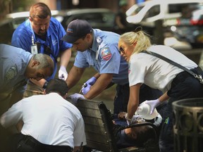 FILE - In this Thursday, Aug. 16, 2018 file photo, paramedics and EMT members respond to one of three simultaneous drug overdose victims on the New Haven Green, a city park in New Haven, Conn. Police swarmed a Connecticut park near Yale University and searched people's homes for drugs Thursday in an effort to prevent more overdoses from a batch of synthetic marijuana blamed for sending more than 70 people to the hospital.
