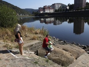 People visit one of the so called 'hunger stones' exposed by the low level of water in the Elbe river in Decin, Czech Republic, Thursday, Aug. 23, 2018.