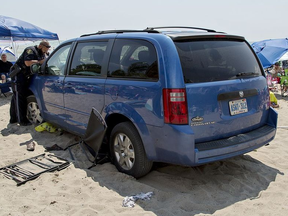 A Norfolk County OPP officer takes photographs of a van that was driven onto the beach at Port Dover just before noon on Saturday August 4, 2018. Police credit a father for his quick thinking to remove his family from harm's way. The family's belongings can be seen, including a chair wedged under the rear wheel of the vehicle. Witnesses say it's a miracle no one was injured or killed in the incident, and that bystanders quickly surrounded the van and pulled a severely intoxicated male from the driver's seat and subdued him until police arrived. BRIAN THOMPSON / BRANTFORD EXPOSITOR