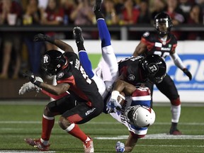 Alouettes receiver Ernest Jackson gets upended by Redblacks defenders Jonathan Rose (9) and Quentin Gause (32) during the second half of the last CFL matchup between the teams in Ottawa on Aug. 11.