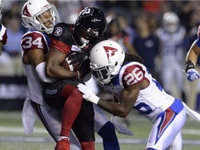 Montreal Alouettes linebacker Glenn Love (34) and Montreal Alouettes defensive back Tevaughn Campbell (26)stop Ottawa Redblacks running back William Powell (29) during first half CFL action in Ottawa on Friday, Aug. 31, 2018.
