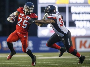 Redblacks linebacker Kyries Hebert, right, grabs for Stampeders running back Don Jackson during a June 28 game at Calgary. THE CANADIAN PRESS/Jeff McIntosh