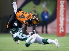 Lions receiver Emmanuel Arceneaux (84) is upended by Roughriders defender Matt Elam after making a reception during the first half of a game in Vancouver on Saturday night.