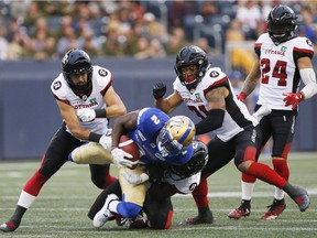 Blue Bombers receiver Kenbrell Thompkins gets hauled down by Redblacks linebacker Avery Williams (42) during the first half of the Friday, August 17 game in Winnipeg.