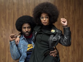 This image released by Focus Features shows John David Washington, left, and Laura Harrier in a scene from "BlacKkKlansman."