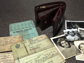 In this August 20, 2018 photo, the lost wallet of Robert McCusker, a war veteran who served in World War II and Korea, is displayed with its contents on a kitchen table in Dover, N.H. McCusker lost his wallet almost 65 years ago in France. It was found at a construction site and returned to his family in New Hampshire.