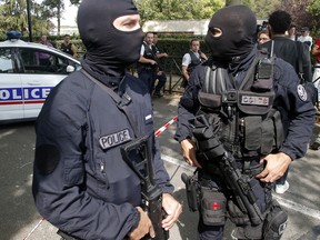 French hooded police officers guard the area after a knife attack Thursday, Aug. 23, 2018 in Trappes, west of Paris.