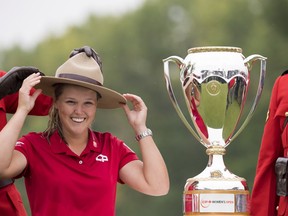 Brooke Henderson of Smiths Falls, ON tries on RCMP hat as she accepts the trophy after winning the CP Women's Open in Regina, Sunday, August 26, 2018.