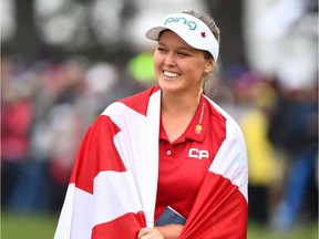 Canada's Brooke Henderson is wrapped in a Canadian flag as she celebrates her win at the CP Women's Open in Regina on Sunday, August 26, 2018.