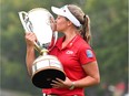 Smiths Falls' Brooke Henderson kisses the trophy as she celebrates her win at the CP Women's Open in Regina on Sunday.