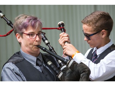 Erin Shaheen has fellow bagpiper Rory Mackinnon adjust the drones on her bagpipes before competing.