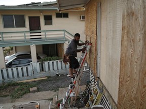 Kaipo Popa secures plywood to protect windows on a home in preparation for Hurricane Lane, Wednesday, Aug. 22, 2018, in Kapolei, Hawaii. As emergency shelters opened, rain began to pour and cellphone alerts went out, the approaching hurricane started to feel real for Hawaii residents.