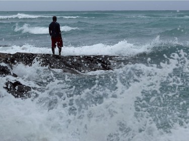 A man stands along the beach as waves crash on shore before Hurricane Lane in Honolulu on Thursday.