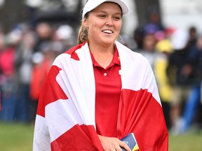 Canada's Brooke Henderson is wrapped in a Canadian flag as she celebrates her win at the CP Women's Open in Regina on Sunday, August 26, 2018.