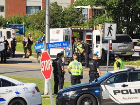 Police and RCMP officers survey the area of a shooting in Fredericton, N.B. on Friday, August 10, 2018.