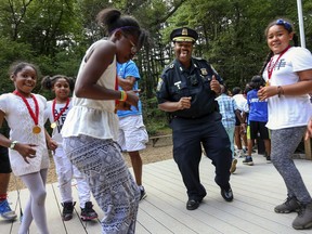 In this Aug. 25, 2017 photo, Boston Police Superintendent-In-Chief William Gross, second from right, joins campers in the first-ever "Dance with a Cop" competition at YMCA Camp Ponkapoag in Milton, Mass. Gross will be sworn in as Boston's first African American police commissioner on Monday, Aug. 6, 2018.