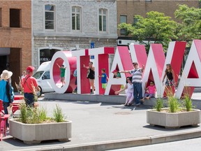 Tourists pose with the Ottawa sign as a study is launched for the ByWard Market on use of public spaces.