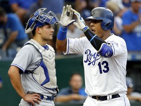 Kansas City Royals' Salvador Perez crosses the plate in front of Toronto Blue Jays catcher Luke Maile after hitting a two-run home run during the first inning of a baseball game Wednesday, Aug. 15, 2018, in Kansas City, Mo.