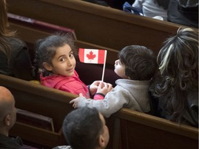 FILE: Syrian refugee Anna Maria (LEFT) looks on with a Canadian flag with cousin Sean Danile (RIGHT) in 2015.