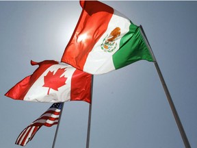 National flags of the United States, Canada, and Mexico fly in the breeze in New Orleans on April 21, 2008. The Canadian government may have been left out of NAFTA talks between the U.S. and Mexico last week and again this week -- but federal insiders insist they're cautiously encouraged Canada's continental partners are once again working out their bilateral sticking points.