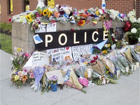 A makeshift tribute outside the police station in Fredericton on Saturday, Aug. 11, 2018. Two city police officers were among four people who died in a shooting in a residential area on the city's north side.