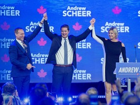 Conservative Party of Canada Leader Andrew Scheer, accompanied by his wife Jill, is introduced by former Conservative cabinet minister Peter MacKay, left, at the party's national policy convention in Halifax on Friday, Aug. 24, 2018.
