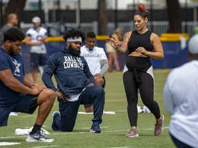 FILE - In this July 28, 2018, file photo, Dallas Cowboys offensive tackle La'el Collins, left and running back Ezekiel Elliott, center, listen to yoga instructor Stacey Hickman, right, as the team does some flexibility exercises at NFL football training camp in Oxnard, Calif.