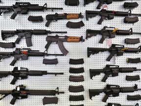 In this July 20, 2014 file photo, guns are displayed for sale by an arms seller east of Colorado Springs, Colo.