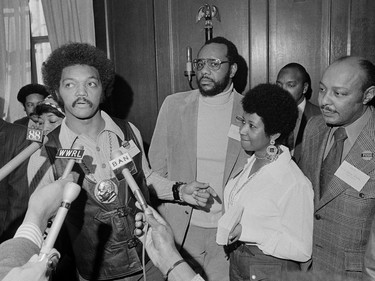 This March 26, 1972 file photo shows the Rev. Jesse Jackson speaking to reporters at the Operation PUSH Soul Picnic in New York as Tom Todd, vice president of PUSH, from second left, Aretha Franklin and Louis Stokes.