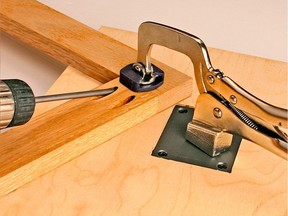A pocket joint being assembled as part of a wooden frame. Screws driven into the back face of the joint draw parts together while the clamp holds parts in alignment.
