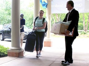 Cathleen Dacey, 23, a Quinnipiac University law student, gets help from Masonicare CEO J.P. Venoit, right, as she moves into Masonicare at Ashlar Village, a retirement community in Wallingford, Conn. Dacey will live at the center this school year as part of an intergenerational learning program.