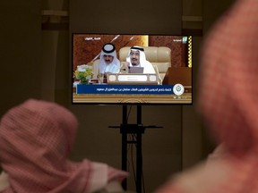 Reporters watch the speech of Saudi King Salman from a press room, during the opening of the Arab summit in Dhahran, Saudi Arabia, Sunday, April 15, 2018.