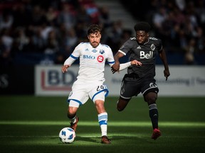 Montreal Impact's Michael Petrasso and Vancouver Whitecaps' Alphonso Davies vie for the ball.