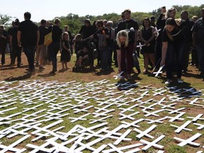 In this photo taken Oct. 30, 2017 people place white crosses, representing farmers killed in the country, at a ceremony at the Vorrtrekker Monument in Pretoria, South Africa.  U.S. President Donald Trump has tweeted that he has asked the Secretary of State Mike Pompeo to "closely study the South African land and farm seizures and expropriations and the large scale killing of farmers." Trump added, "South African Government is now seizing land from white farmers."