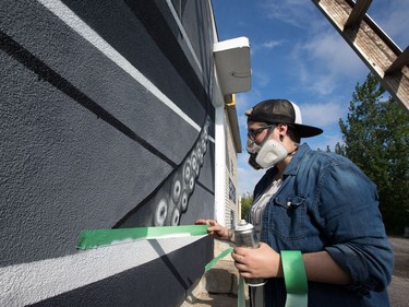 Alyssa Longchamps, 26, is usually tattooing humans with her unique style of black and white art but for the last couple of weeks she has been spray painting a giant 14' x 38' squid on the outside wall of the Merivale Fish and Seafood Grill on Merivale Road. A friend of the owners, she was asked if she could come up with a design that would celebrate the seafood nature of the business and after some thought, she sketched up the squid. She took a week off from tattooing at her private studio, "The Static Lab", and battled the brutal heat and thunderstorms and recently finished the project. "It was a lot of fun, I'm pretty excited about it. I don't know if I'll do more (because) it's been pretty time consuming, but I definitely enjoyed it," she said.