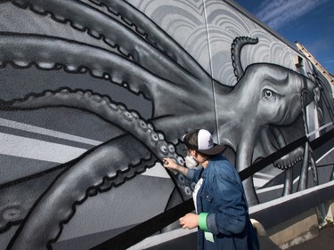 Alyssa Longchamps, 26, is usually tattooing humans with her unique style of black and white art but for the last couple of weeks she has been spray painting a giant 14' x 38' squid on the outside wall of the Merivale Fish and Seafood Grill on Merivale Road. A friend of the owners, she was asked if she could come up with a design that would celebrate the seafood nature of the business and after some thought, she sketched up the squid. She took a week off from tattooing at her private studio, "The Static Lab", and battled the brutal heat and thunderstorms and recently finished the project. "It was a lot of fun, I'm pretty excited about it. I don't know if I'll do more (because) it's been pretty time consuming, but I definitely enjoyed it," she said.