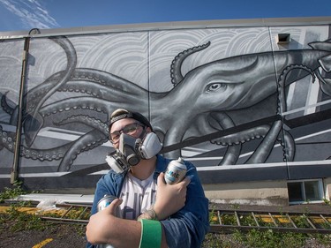 Alyssa Longchamps, 26, is usually tattooing humans with her unique style of black and white art but for the last couple of weeks she has been spray painting a giant 14' x 38' squid on the outside wall of the Merivale Fish and Seafood Grill on Merivale Road. A friend of the owners, she was asked if she could come up with a design that would celebrate the seafood nature of the business and after some thought, she sketched up the squid. She took a week off from tattooing at her private studio, "The Static Lab", and battled the brutal heat and thunderstorms and recently finished the project. "It was a lot of fun, I'm pretty excited about it. I don't know if I'll do more (because) it's been pretty time consuming, but I definitely enjoyed it," she said.  Photo by Wayne Cuddington/ Postmedia