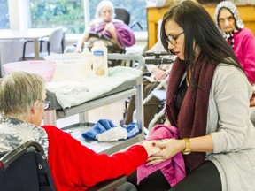 Holly Reandy, a therapeutic recreation aide at Northcrest Care Centre in Delta, massages the hands of one of the residents as part of a touch-therapy practice on Jan. 14, 2016.