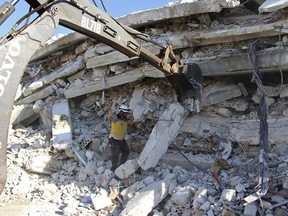 This photo provided by the Syrian Civil Defense White Helmets, which has been authenticated based on its contents and other AP reporting, shows Syrian White Helmet civil defense workers at the scene of an explosion that brought down a five-story building, in the village of Sarmada, near the Turkish border, north Syria, Sunday, Aug. 12, 2018. Syrian opposition activists say the explosion killed several people and wounded many others. The cause of the blast wasn't immediately known.