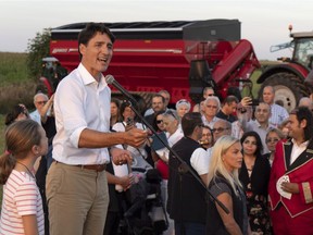Prime Minister Justin Trudeau addresses local Liberals and Liberal MPs from the South Shore of Montreal for a summer corn roast in Sabrevois, Que., on Thursday, August 16, 2018. Trudeau lashed back at a right-wing activist who heckled him about the cost of "illegal immigrants" in Quebec, calling her intolerant and racist.