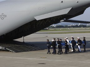 U.N. honor guards carry the remains of U.S. servicemen killed in the Korean War and collected in North Korea, onto an aircraft at the Osan Air Base in Pyeongtaek, South Korea, Wednesday, Aug. 1, 2018. North Korea handed over 55 boxes of the remains last week as part of agreements reached during a historic June summit between its leader Kim Jong Un and U.S. President Donald Trump. (Chung Sung-Jun/Pool Photo via AP) ORG XMIT: BKWS322